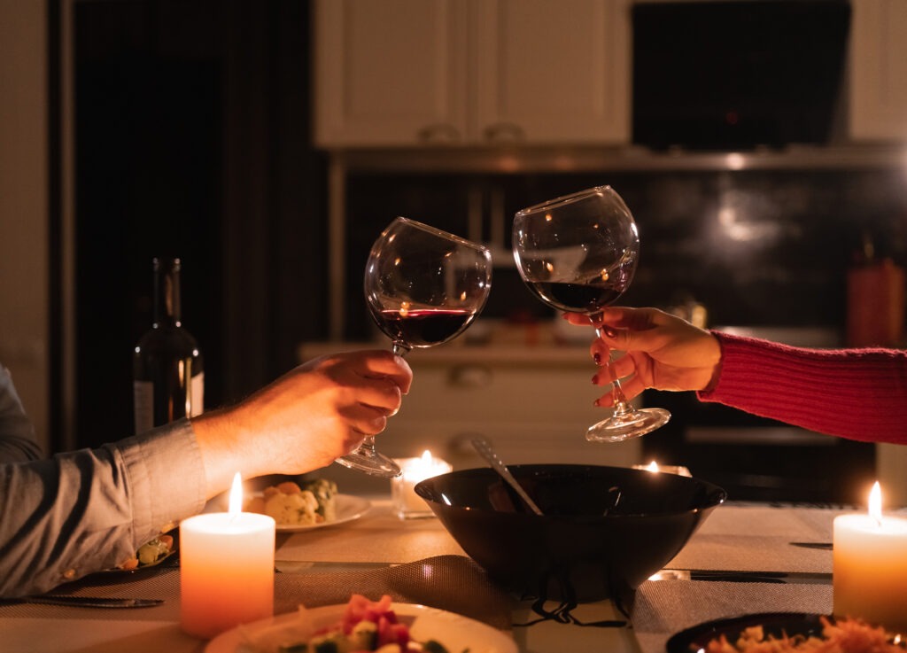 Couple clinking glasses of red wine celebrating valentine's day, romantic date and dinner for two, alcohol in glass, anniversary or valentine's day upper ivy apartments